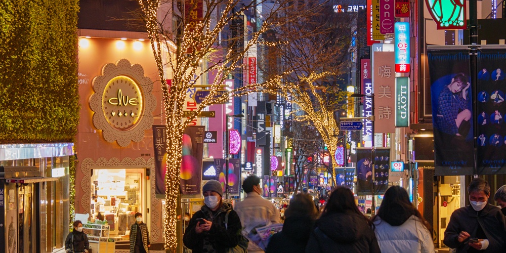 저녁 무렵 불이 켜진 명동 거리와 사람들